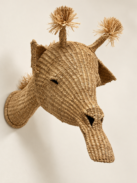 A life-size woven giraffe mounted on a wall
